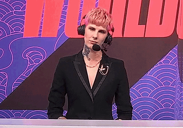 a woman wearing headphones and a microphone stands in front of a sign that says ' i '