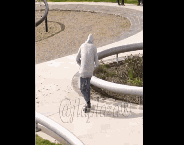 a person wearing a hoodie is walking down a sidewalk with the hashtag @jplaza on the bottom right