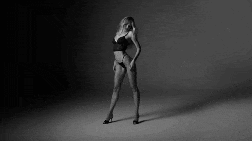 a black and white photo of a woman in black lingerie