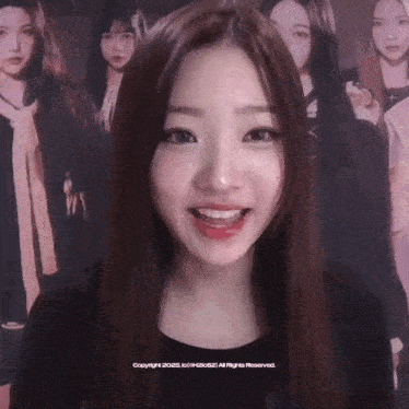 a girl is smiling in front of a poster that says copyright 2021