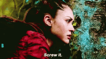 a woman in a red jacket says " screw it " in front of a tree