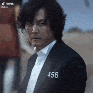 a man in a suit with the number 456 on his chest .