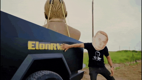 a man wearing a mask is standing in front of a truck that says elonry