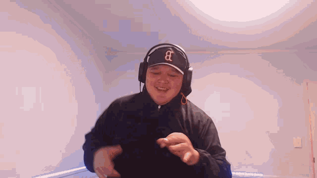 a man wearing headphones and a hat that says b on it