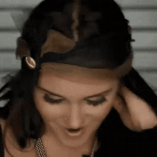 a close up of a woman wearing a wig .