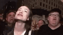 a woman is looking up in a crowd of people .