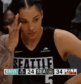 a female basketball player is giving the middle finger during a game while wearing a seattle jersey .
