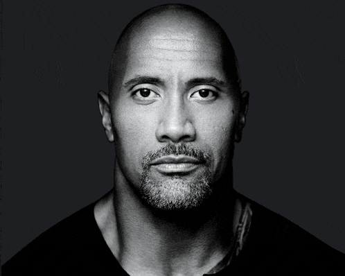 a man with a beard and a bald head looks at the camera