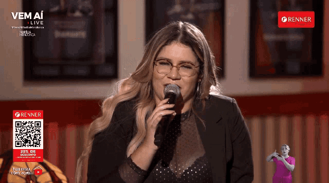 a woman singing into a microphone with a sign that says renner