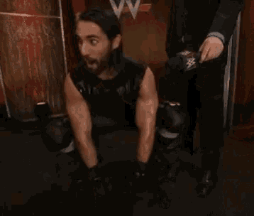 a man with a beard is kneeling down next to a man in a suit .