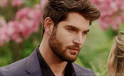 a man with a beard is looking at a woman in a garden .