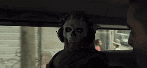 a man in a skull mask is sitting in the back seat of a car .