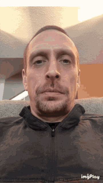 a man with a beard is sitting in a chair and his face is shown in a gif with the words imgplay below him