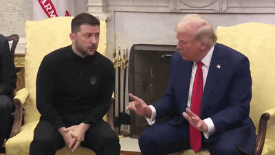 a man in a suit and tie is sitting next to another man