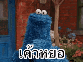 cookie monster from sesame street is standing in front of a blue door
