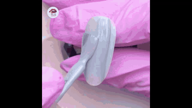 a close up of a person applying nail polish to their nails .