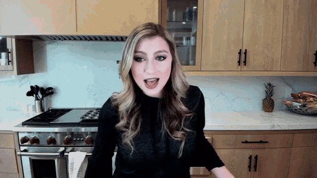 a woman in a kitchen with a wolf stove