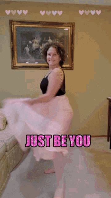 a woman is dancing in a living room with the words just be you written above her