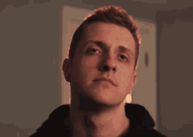 a close up of a man 's face with his eyes closed and a serious look on his face .