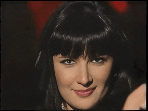 a close up of a woman 's face with black hair and bangs