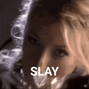 a close up of a woman 's face with the word slay written above her