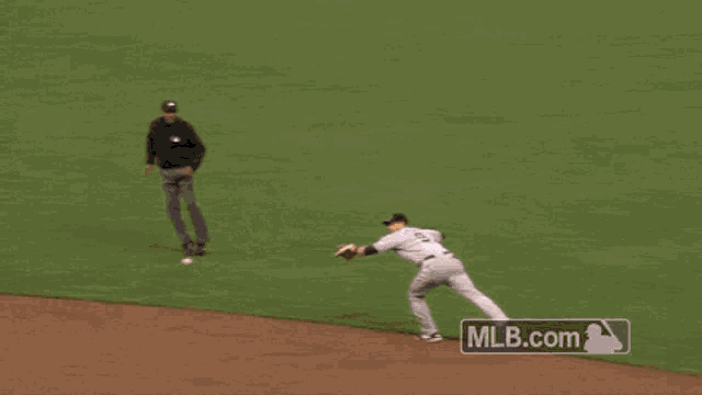 a baseball player reaches for a ball with a mlb.com logo in the corner