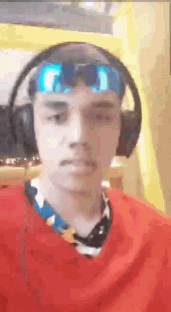 a man wearing headphones and sunglasses is making a funny face .