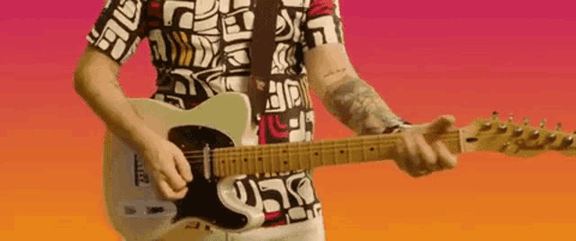 a man in a colorful shirt is playing a guitar against a colorful background .