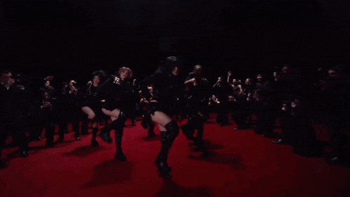 a group of women are dancing on the red carpet