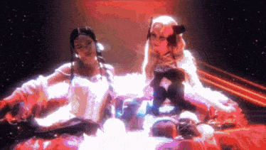 a couple of women are sitting next to each other in a room .