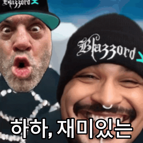 two men are posing for a picture and one has a hat that says blizzard on it
