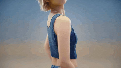a woman wearing a guess crop top and jeans