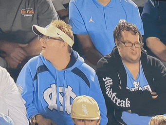 a man wearing a sweatshirt that says dirt sits in a crowd