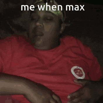 a woman in a red shirt is laying down with her eyes closed and the caption says me when max