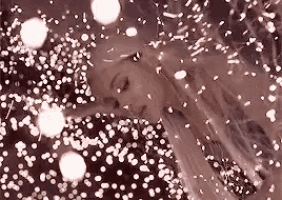 a close up of a woman 's face surrounded by snow and lights .