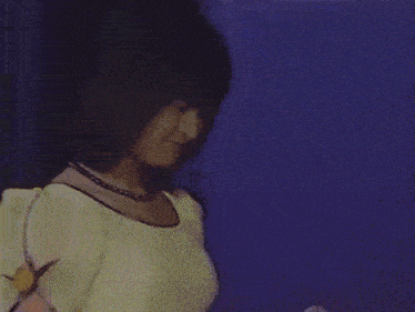 a blurry picture of a woman standing in front of a crowd of people