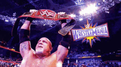 a man in a wrestling ring holding a wrestlemania belt