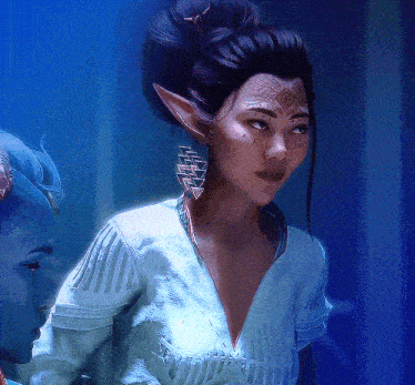 a woman with a tattoo on her face is standing next to a man with horns