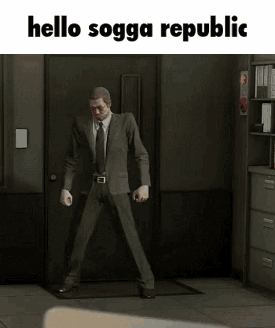 a man in a suit and tie is standing in front of a door with the words hello sogga republic below him .