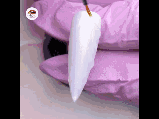 a close up of a nail being painted with a brush and the word nails on the bottom