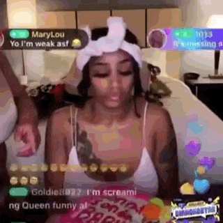 a woman is sitting on a bed wearing a headband and a white tank top .