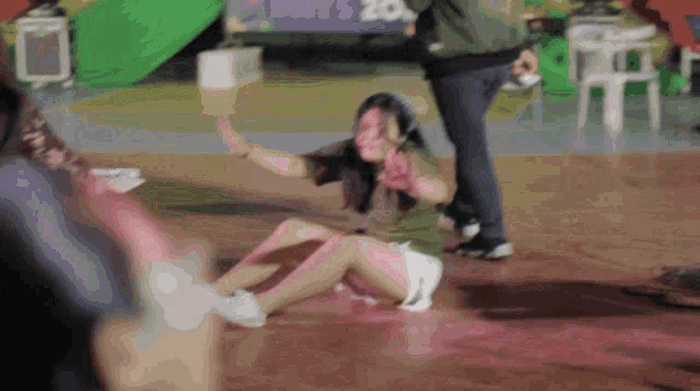 a woman is laying on the floor with a sign in the background that says may 20