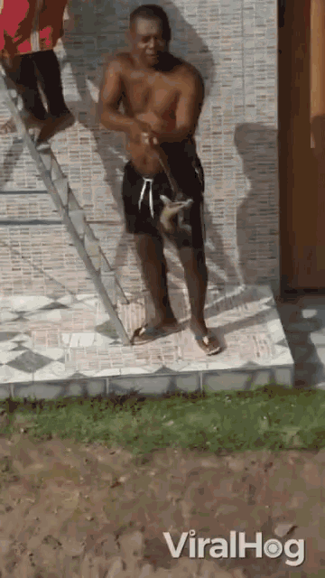 a shirtless man is standing on a tiled floor with a ladder in the background and the hashtag viralhog