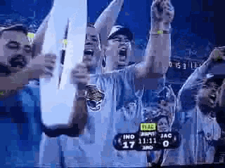 a group of people are watching a football game and the score is 17 to 3rd