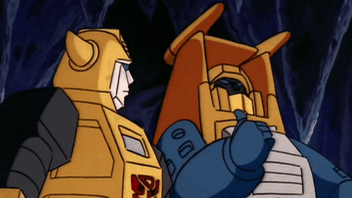 two transformers are standing next to each other and one of them has the letter r on his chest