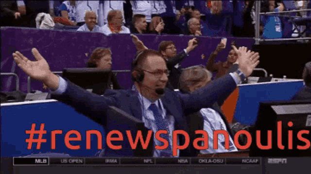a man with his arms outstretched is sitting in front of a screen that says #renewspanoulis