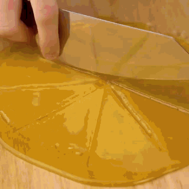 a person is putting a doughnut on top of a chocolate cake on a wooden cutting board .