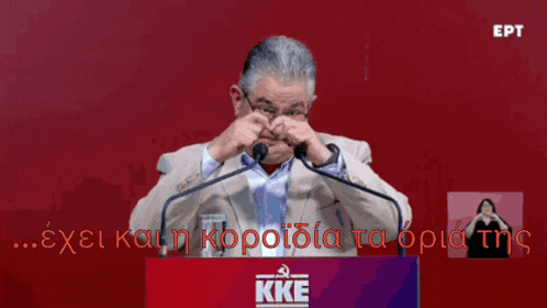 a man stands behind a podium that says kke