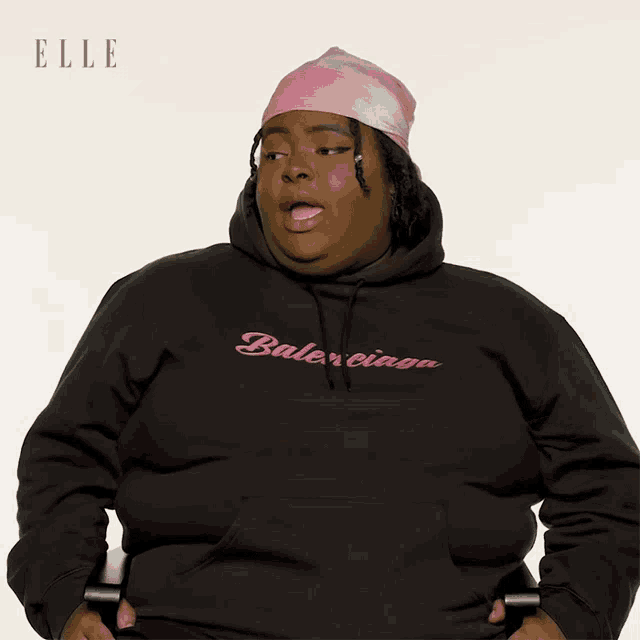 a woman wearing a black balenciaga hoodie makes a face