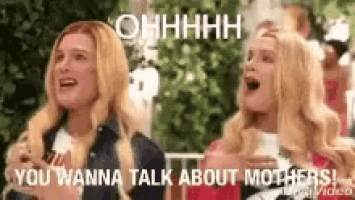 two blonde women are sitting next to each other and laughing .